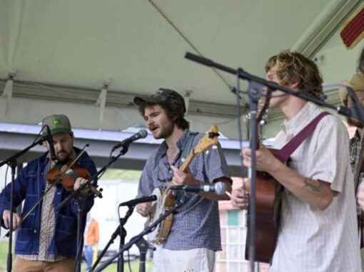 Four men play instruments on stage.